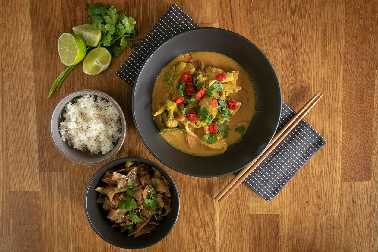 Foto: Tisch mit Reis, thailändischem Curry und thailändischem Salat.