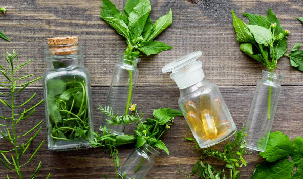 Foto: Kräuter und Tabletten in Glasbehältern 