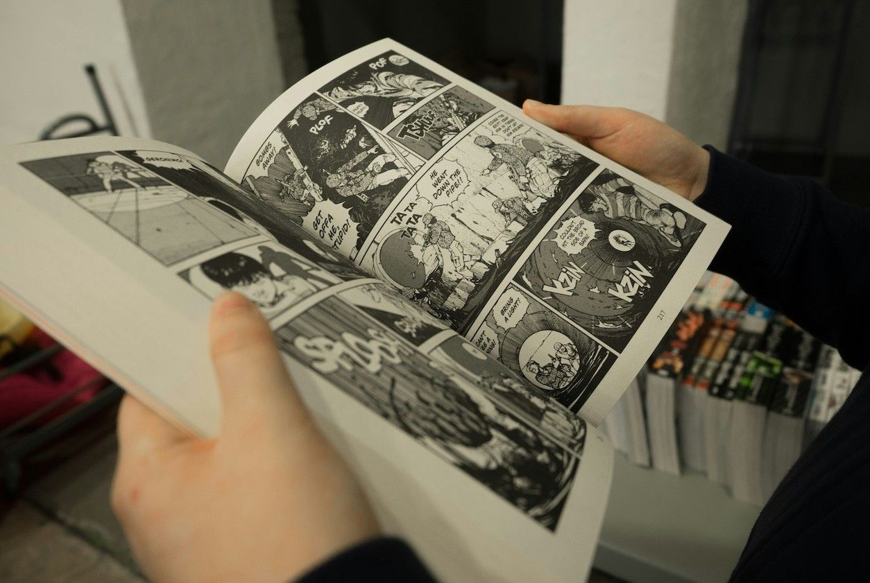 Foto: Eine Person blättert in einem schwarz-weiß Comic