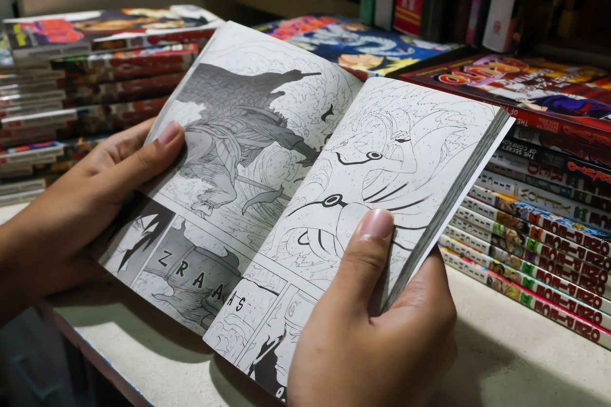 Foto: Eine Person blättert in einem schwarz-weiß Comic