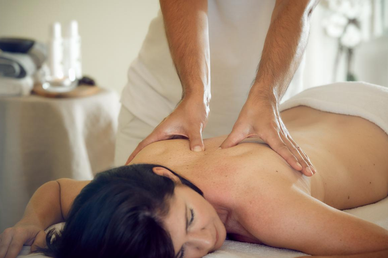 Foto: Ein Mann massiert eine Person am Rücken.