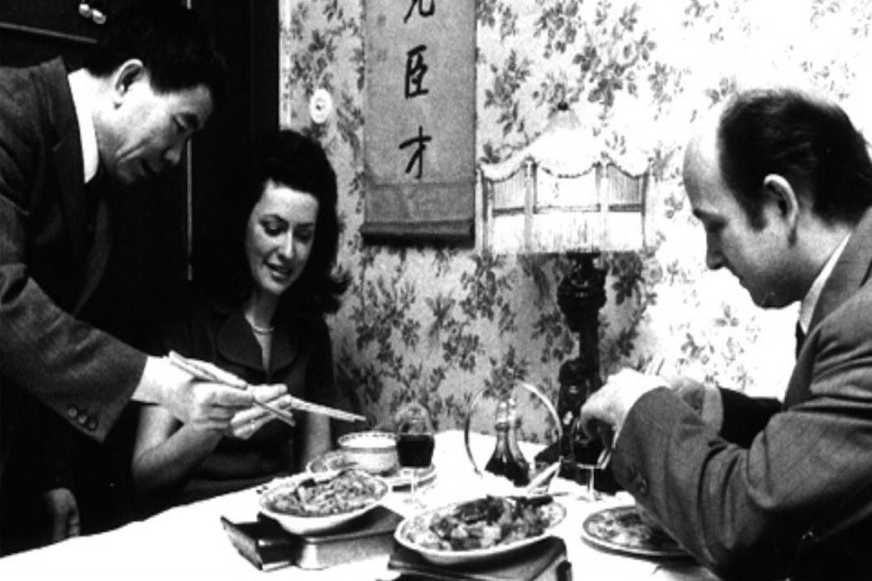 Foto: Ein Mann und eine Frau in einem chinesischen Restaurant werden von einem Kellner serviert.