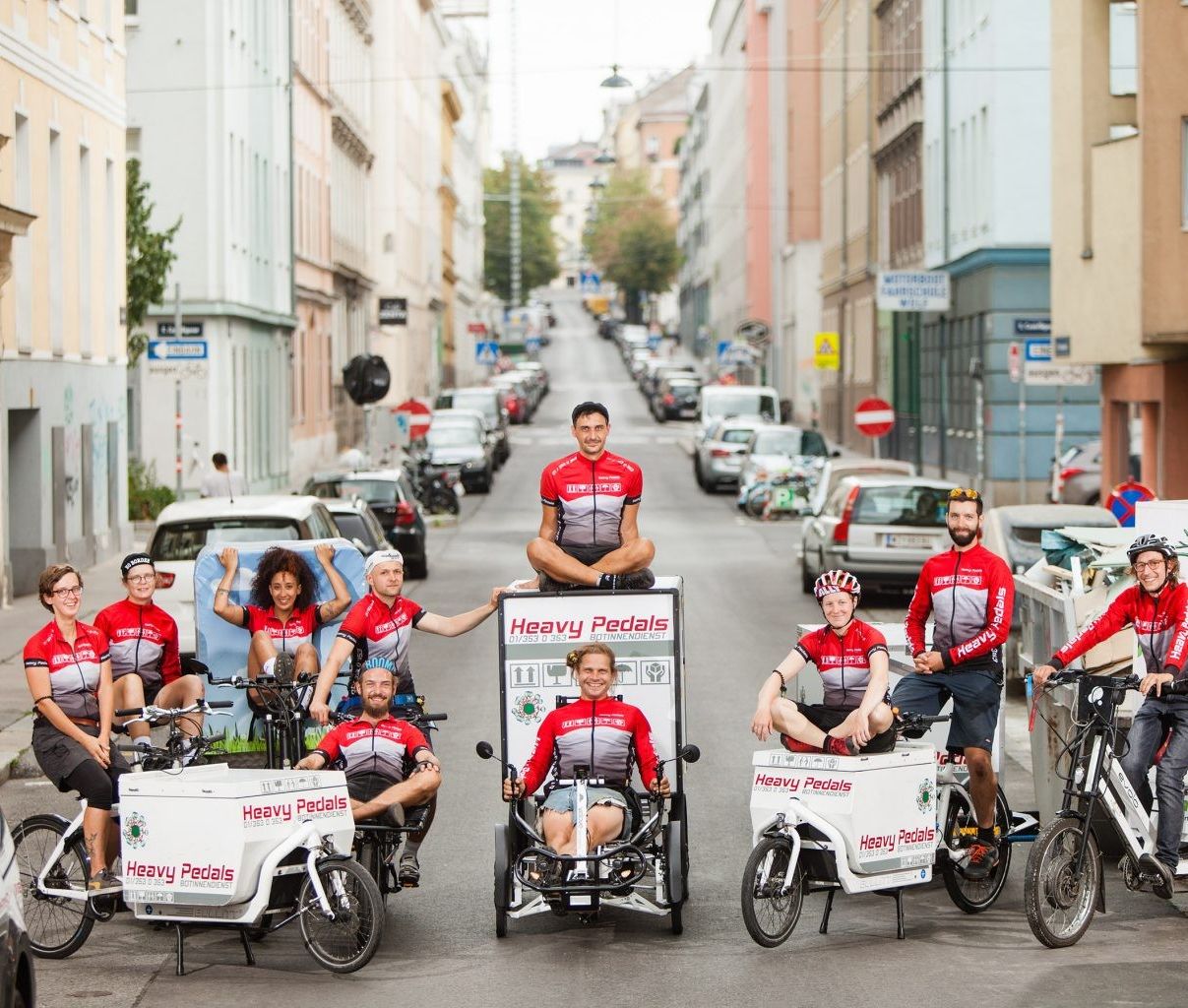 Foto: Eine Gruppe von Menschen auf Lastenfahrräder, die mitten auf der Straße posieren.