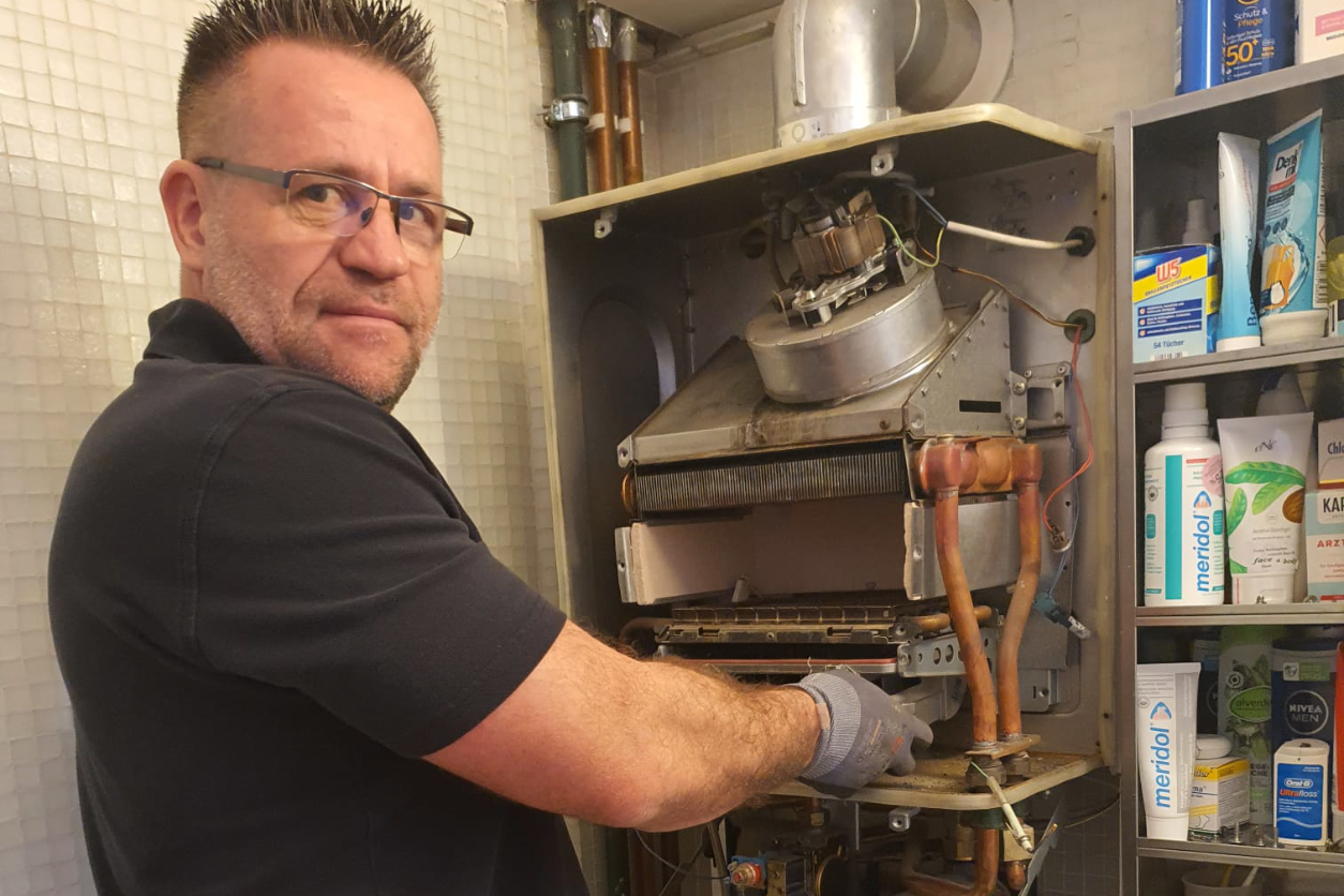 Foto: Ein Mann der an einer Maschine hantiert.