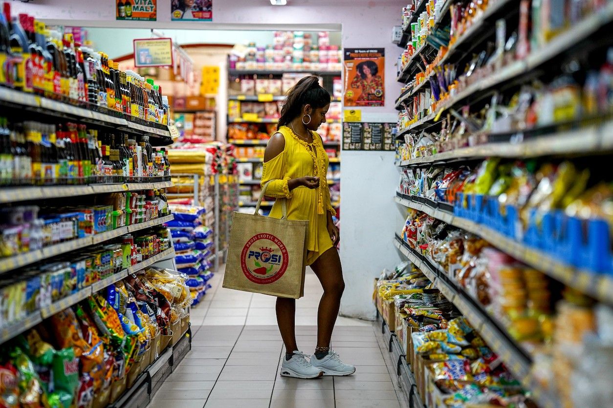 Foto: Supermarkt mit exotischen Produkten und einer Frau mit einer Einkaufstasche