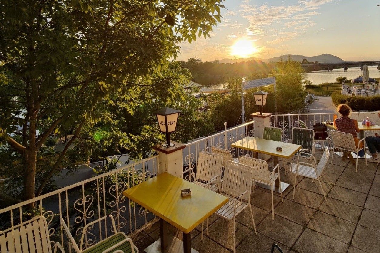 Foto: Tische und Stühle bei Sonnenuntergang