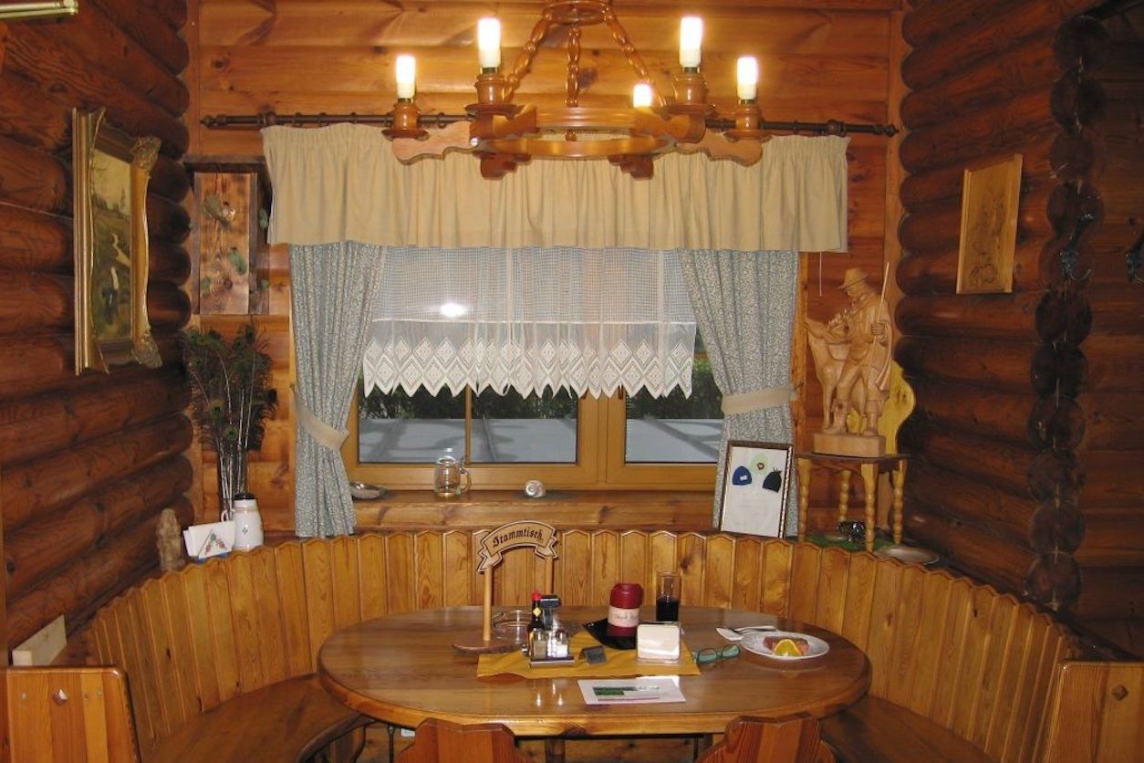 Foto: Gemütlicher Tisch mit einer runden Bank und eine Fenster mit Blick nach draussen. 