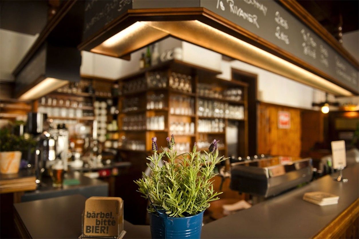 Foto: Zeigt eine Gaststube und eine Tressen mit einem Rosmarin. 