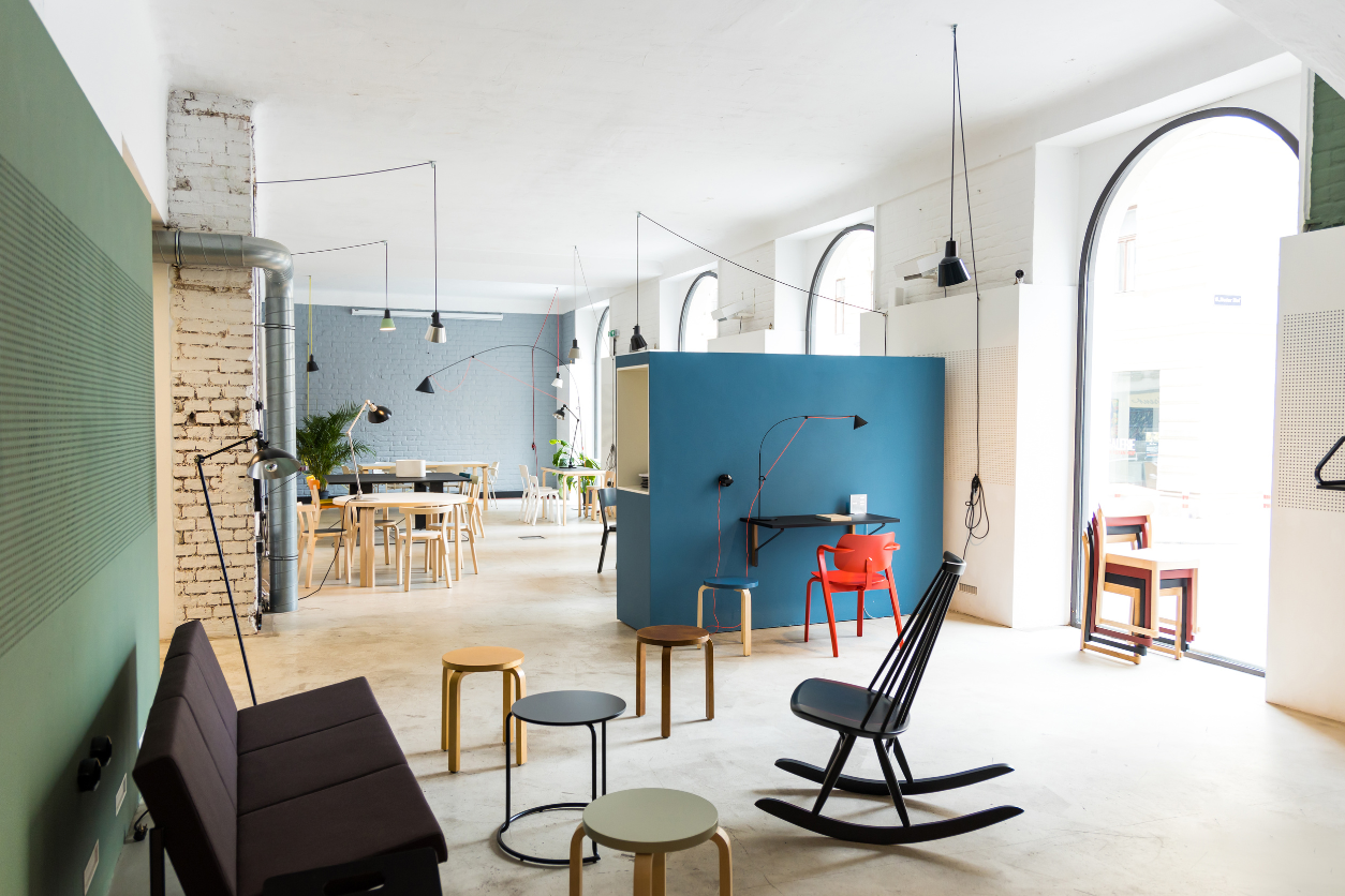 Foto: Zeigt einen offenen Raum kleinen Hockern, Tischen und Sitzmöglichkeiten zum Arbeiten