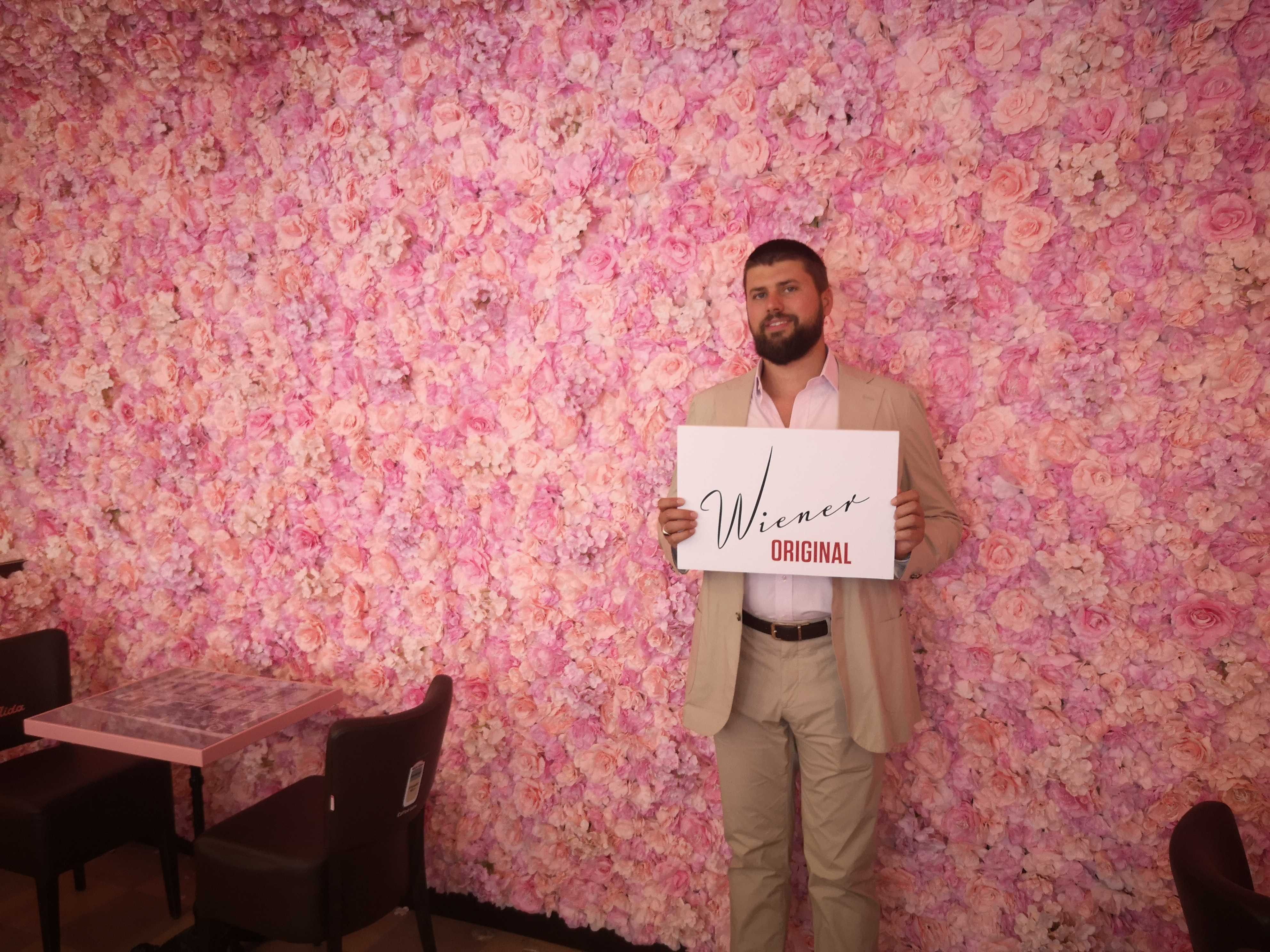 Foto: Mann vor Wand aus Blumen