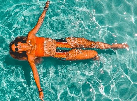 Foto: Eine Frau im Bikini liegt im Wasser und treibt vor sich hin