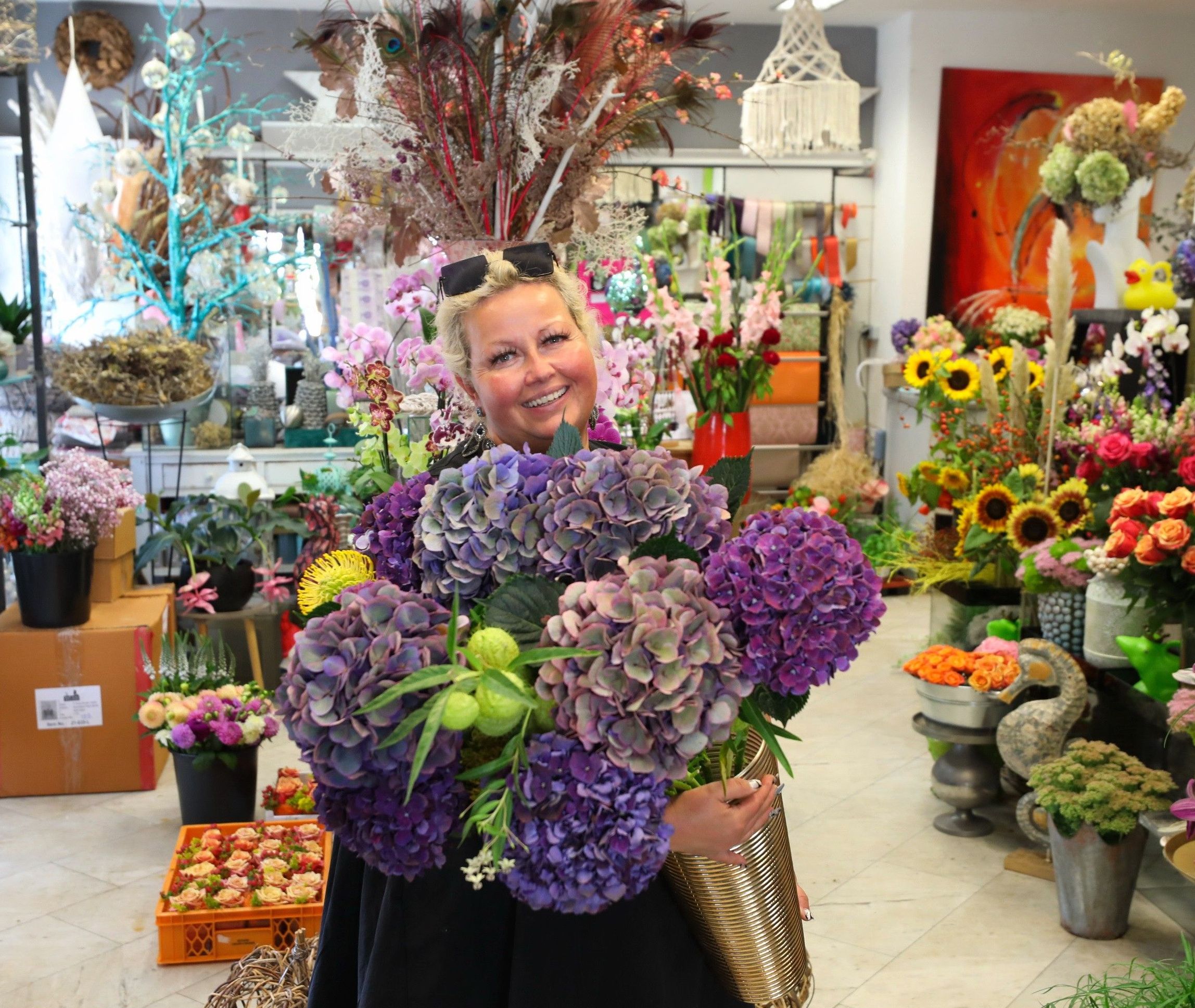 Foto: Innenbereich des Blumengeschäfts Blütenzeit mit Frau, die Blumen in der Hand hält.