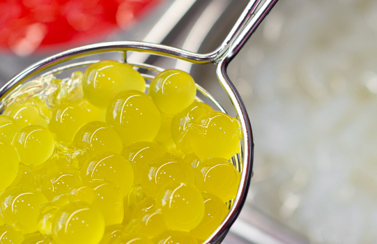 Foto: Gelbe Bubbles in einem Sieb für Bubble Tea