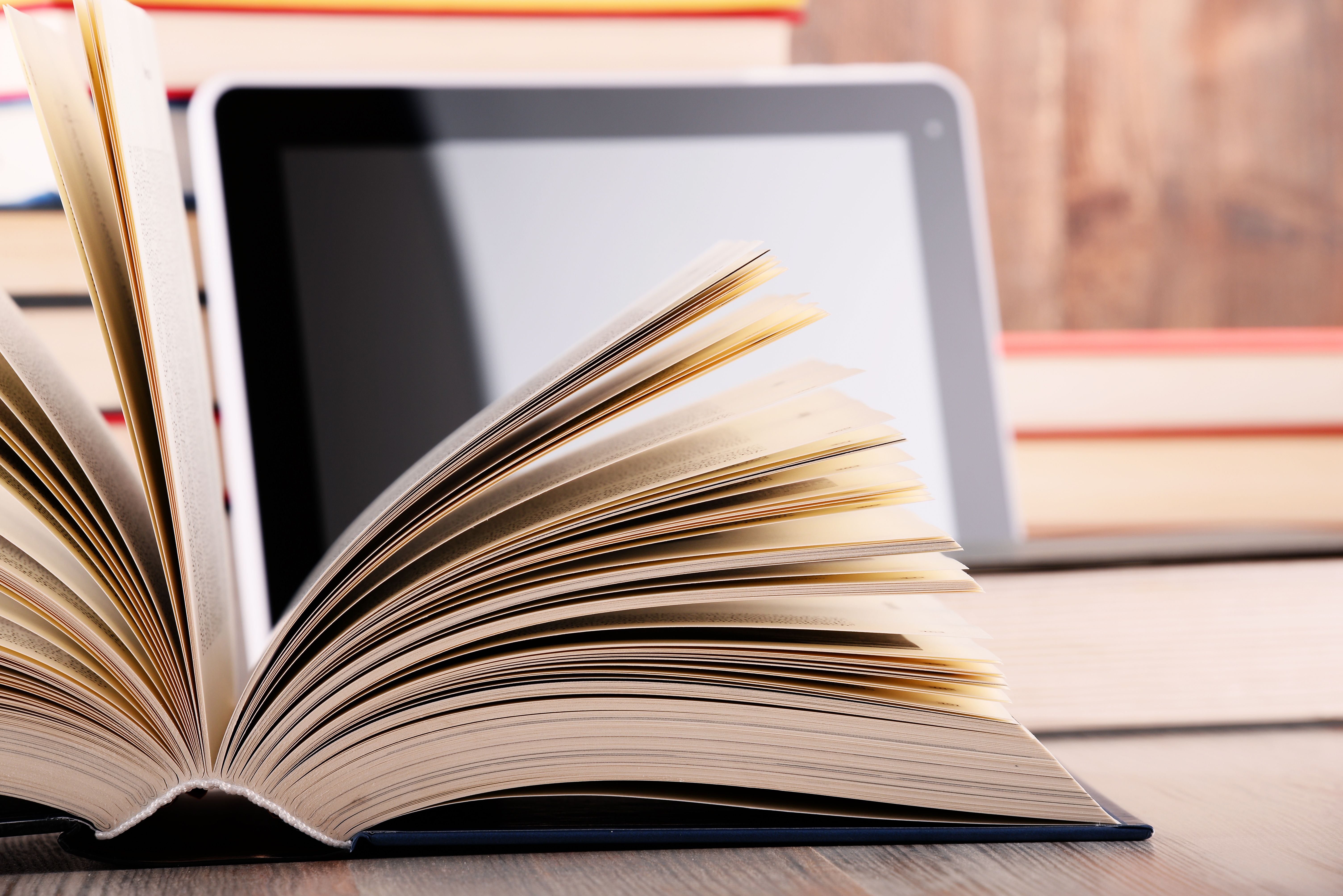 Foto: Aufgeschlagenes Buch vor einem Tablet