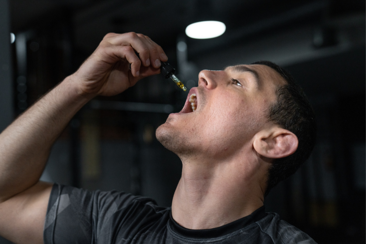 Foto: Eine Person tropft sich CBD Tropen in den Mund