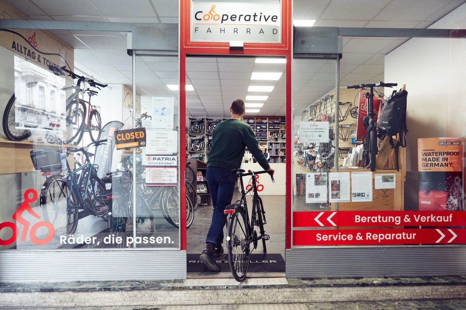 Foto: Eine Person schiebt gerade ein Fahrrad in das Geschäft