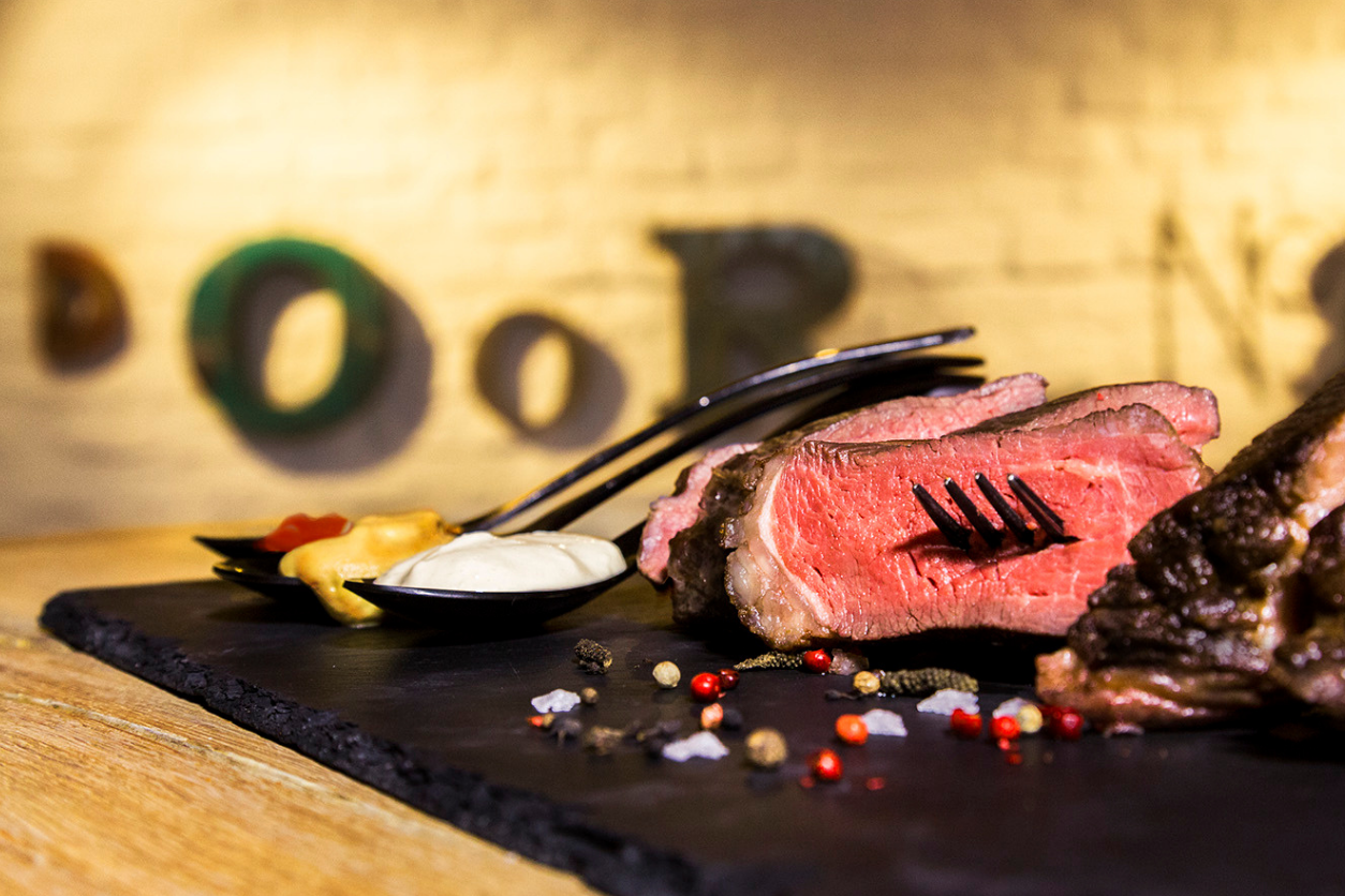 Foto: Ein Steak mit Besteck auf einer Platte