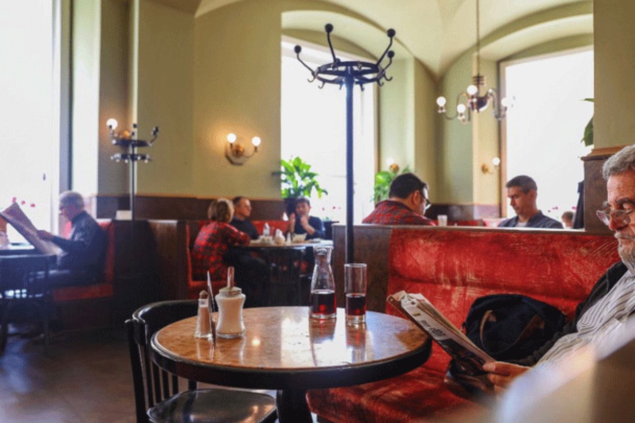 Foto: Kaffeehaus wo Personen sitzen und Zeitung lesen