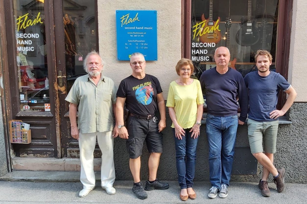 Foto: Eine Personengruppe steht vor dem Geschäft 