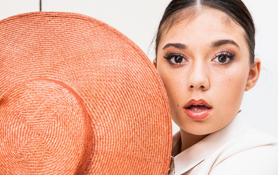 Foto: Frau die einen Hut in der Hand hält