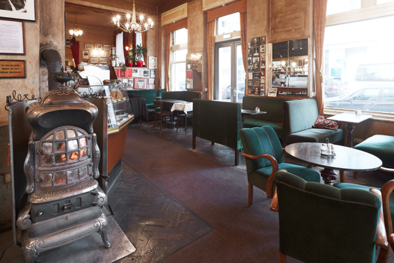 Foto: Kaffeehaus Jelinke mit Kamin und Tisch und Stühlen