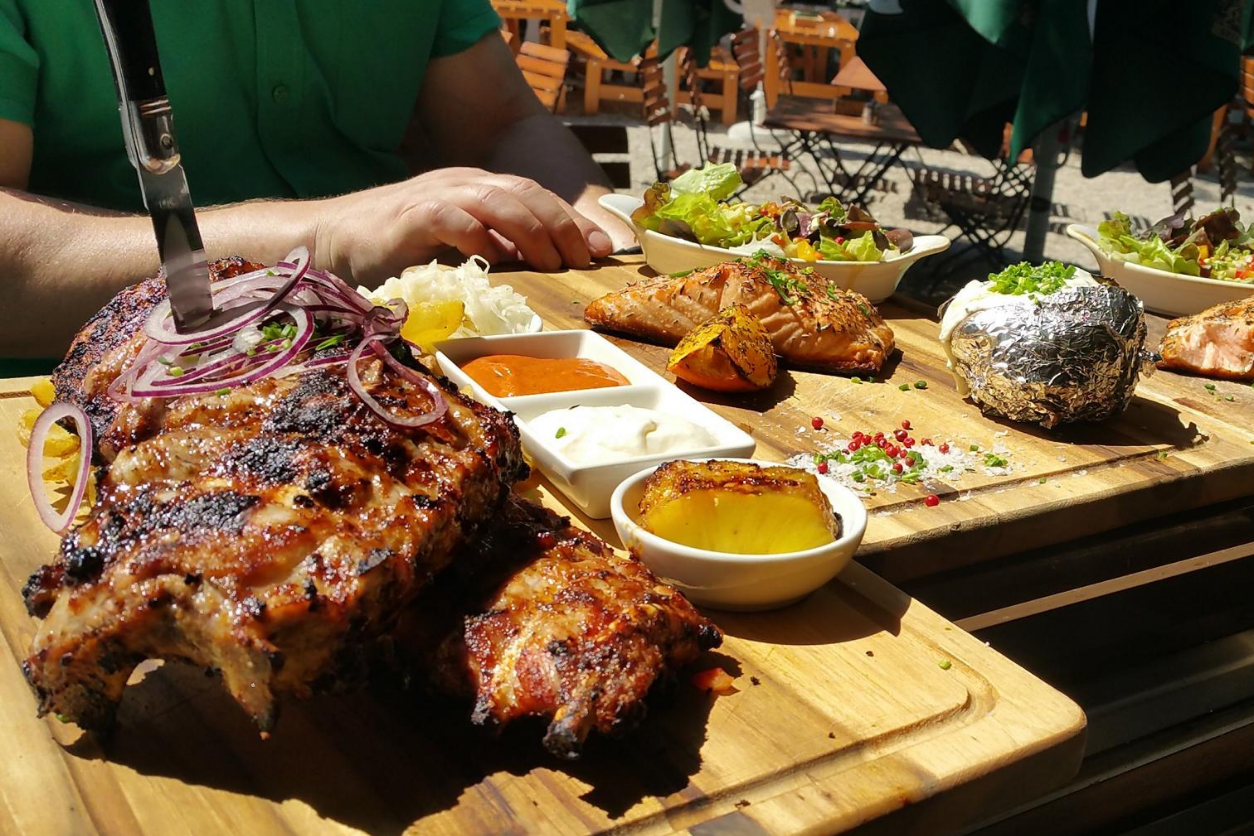 Foto: Rippchen mit Saucen und Kartoffel auf einem Brett