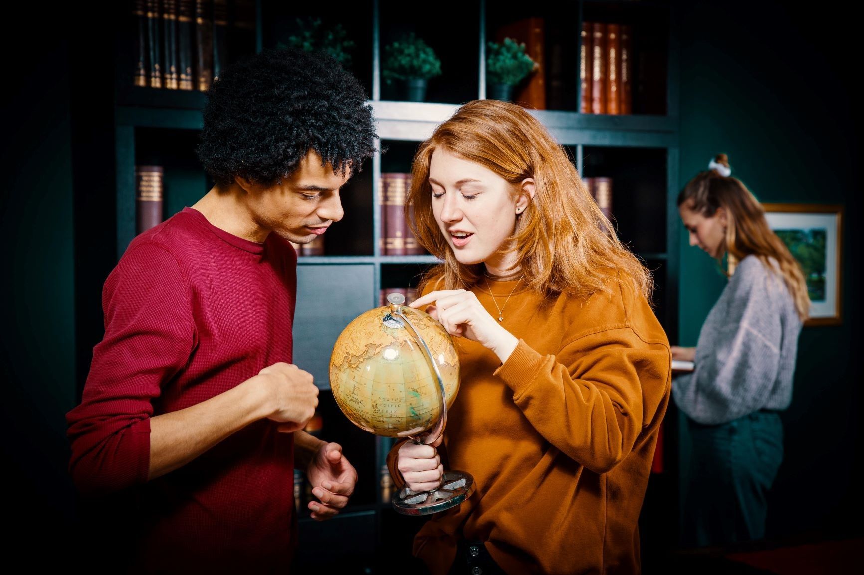 Foto: Zwei Personen schauen auf einen kleine Globus und suchen etwas