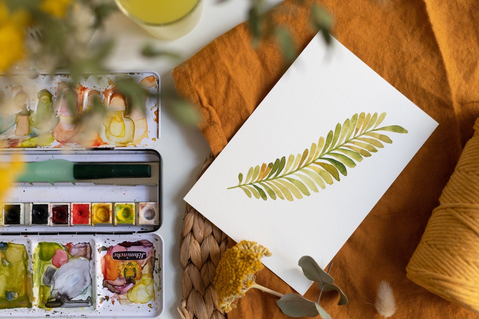 Foto: Ein Blatt Papier mit einem gezeichneten Blatt und Wasserfarben.