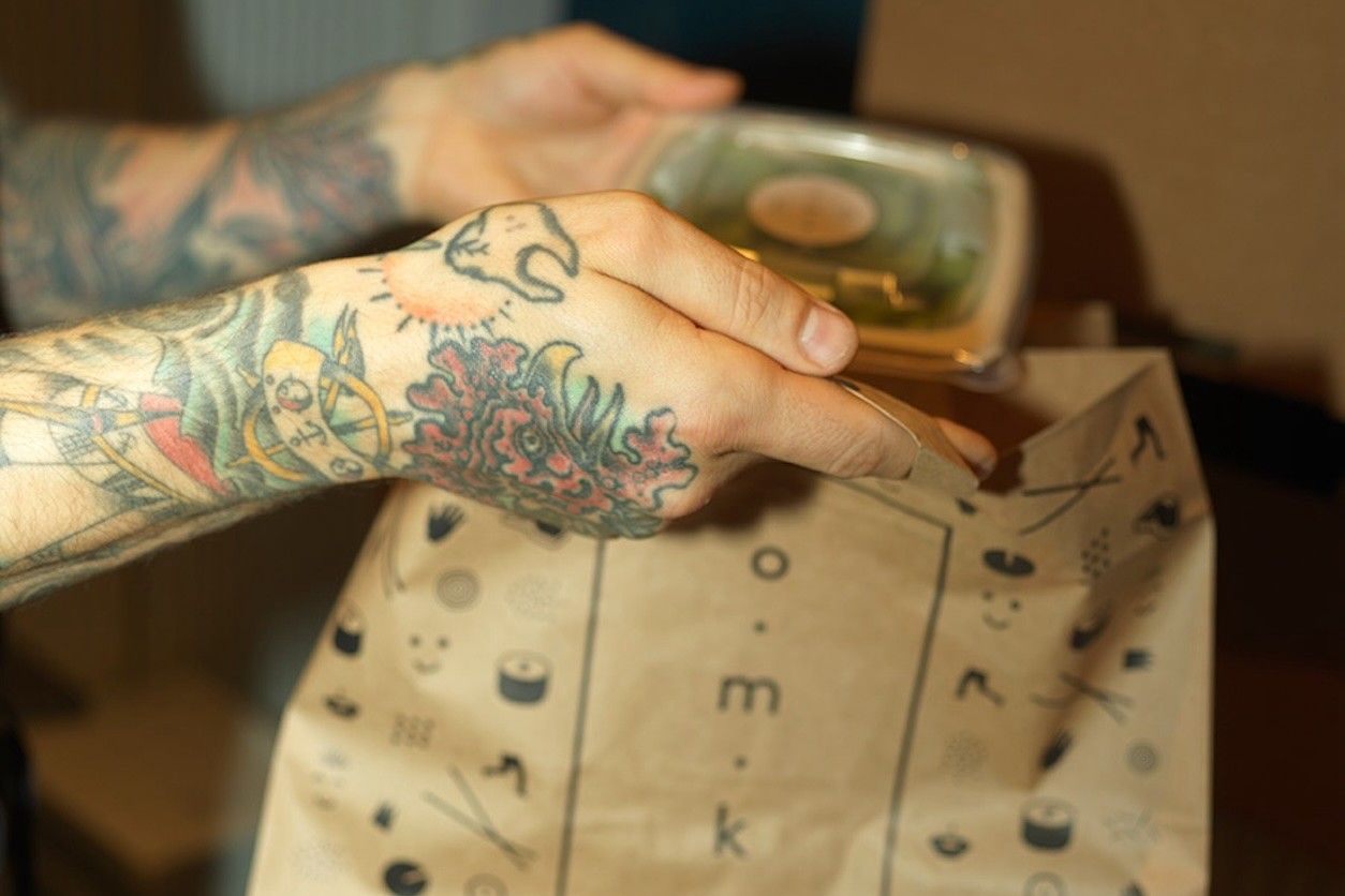 Foto: Eine Person nimmt ein Produkt aus einer Tüte.