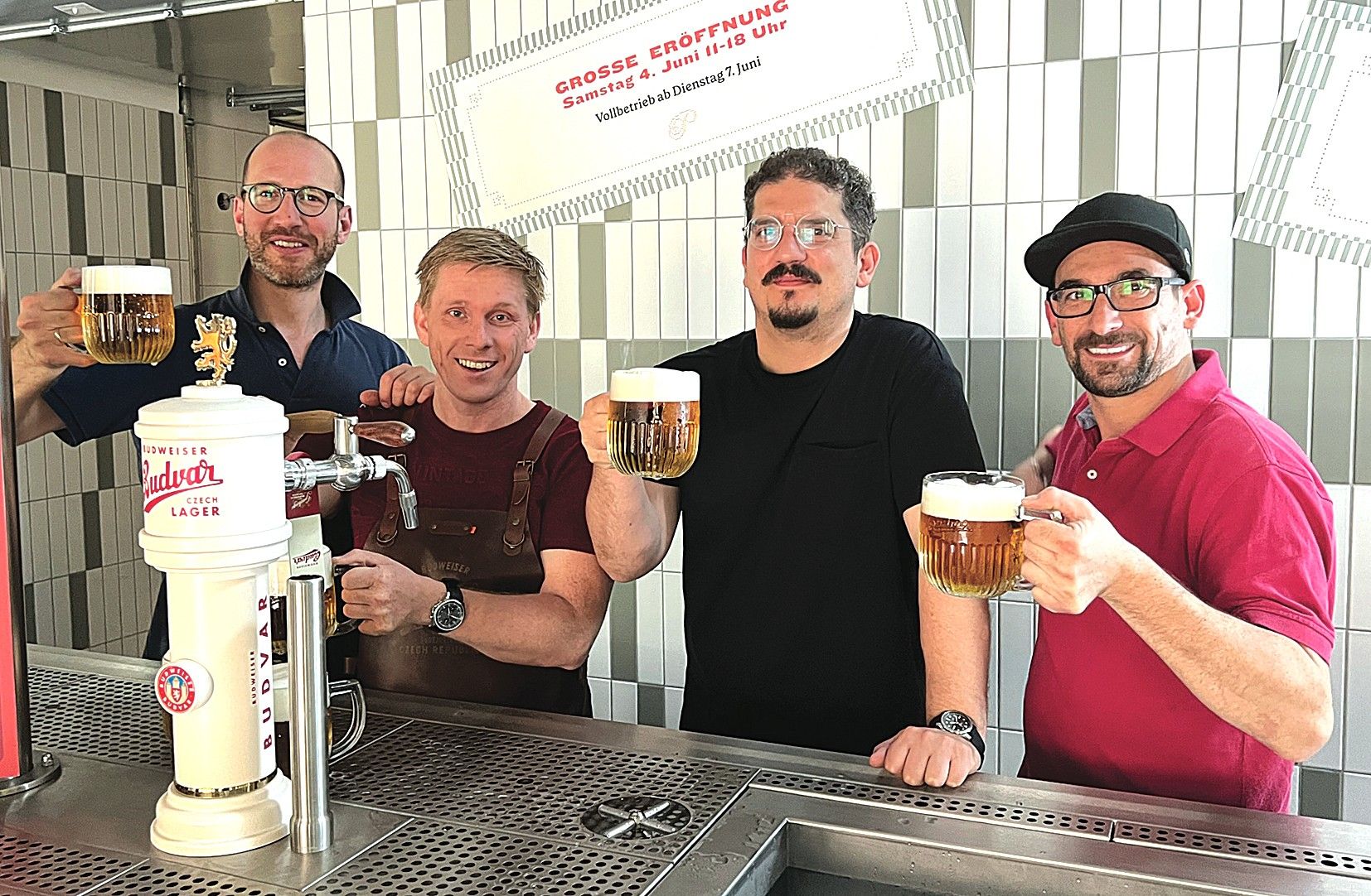 Foto: Männer die Bier zapfen und sich zuprosten