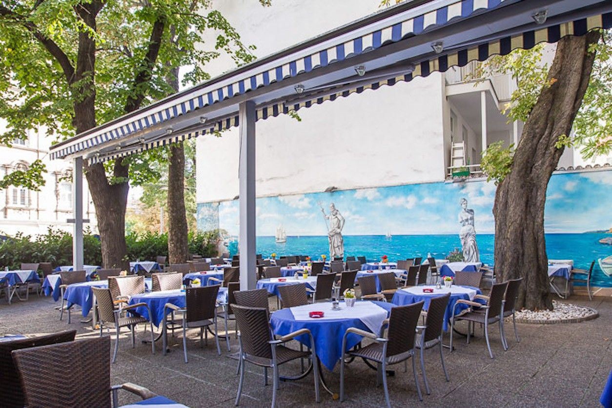Foto: Gastgarten mit Tischen und Stühlen im typisch blau weißem Look