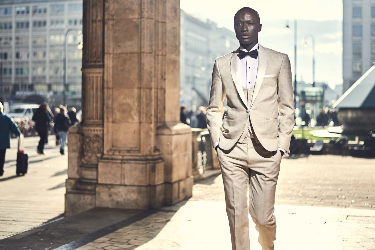 Foto: Ein schwarzer Mann im Anzug geht über einen Platz.