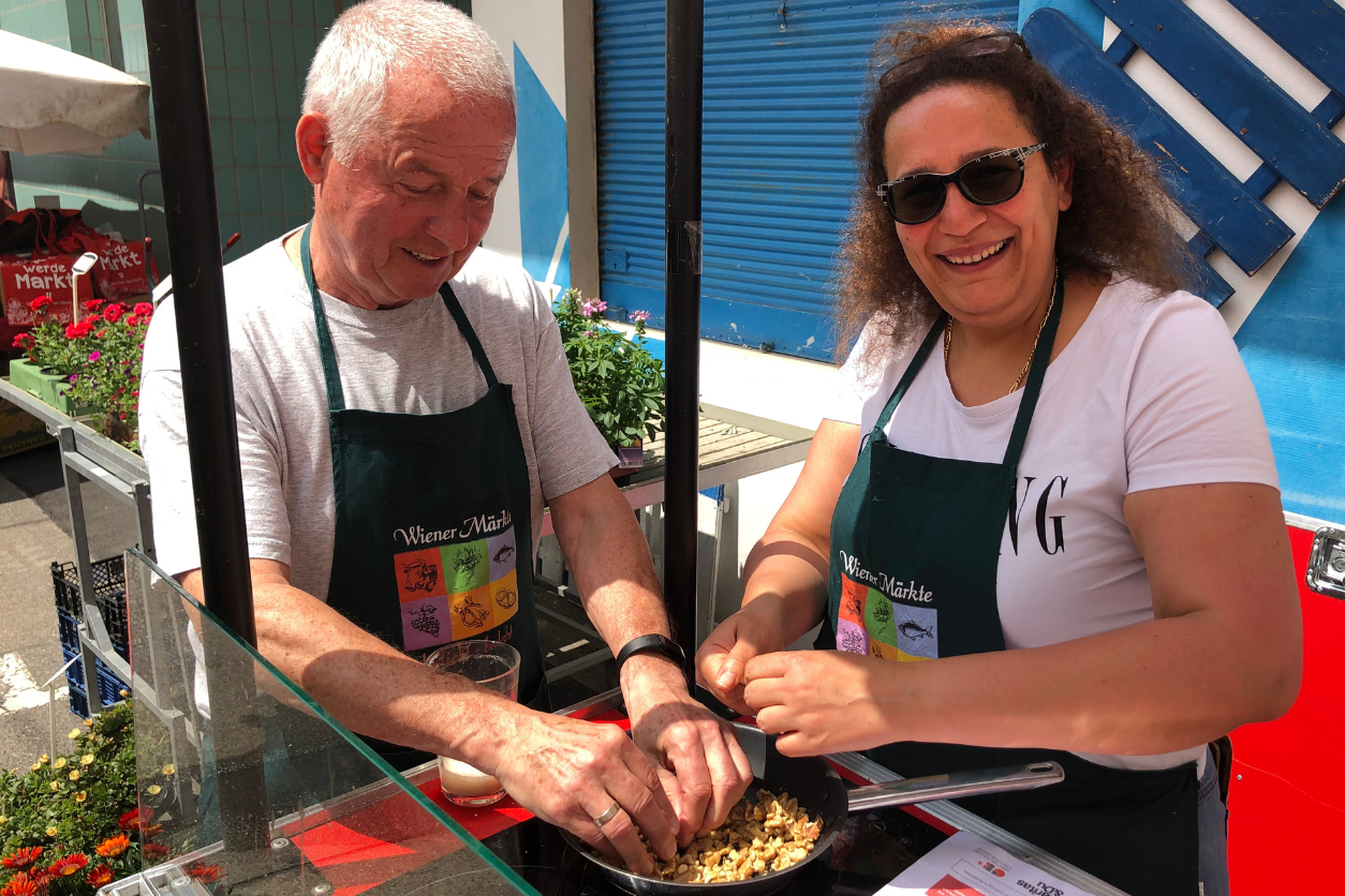 Foto: Zwei Personen stehen draussen und stehen über einer Pfanne