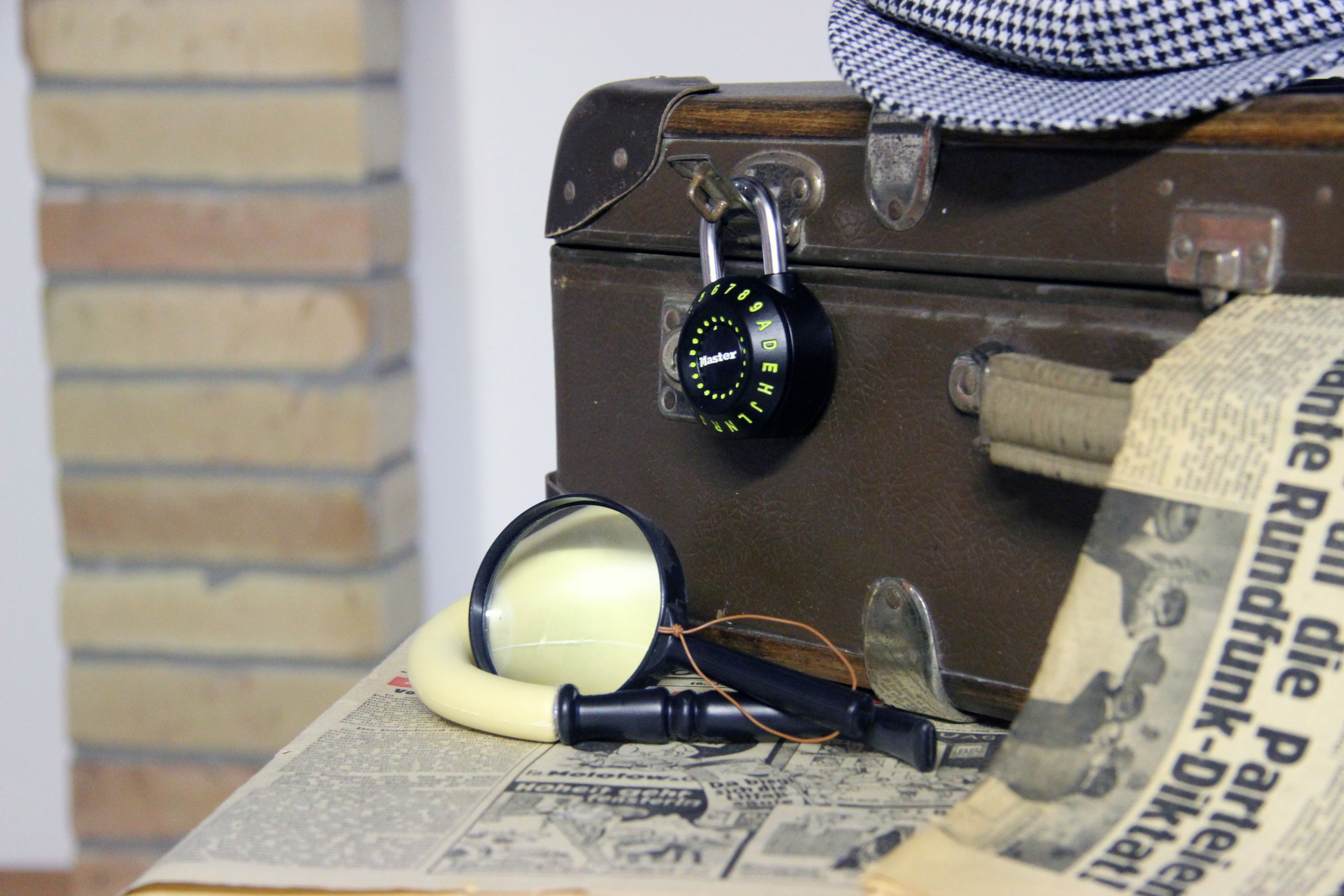 Foto: Zeigt einen alten Koffer mit einem Zahlenschloß und Zeitungspapier
