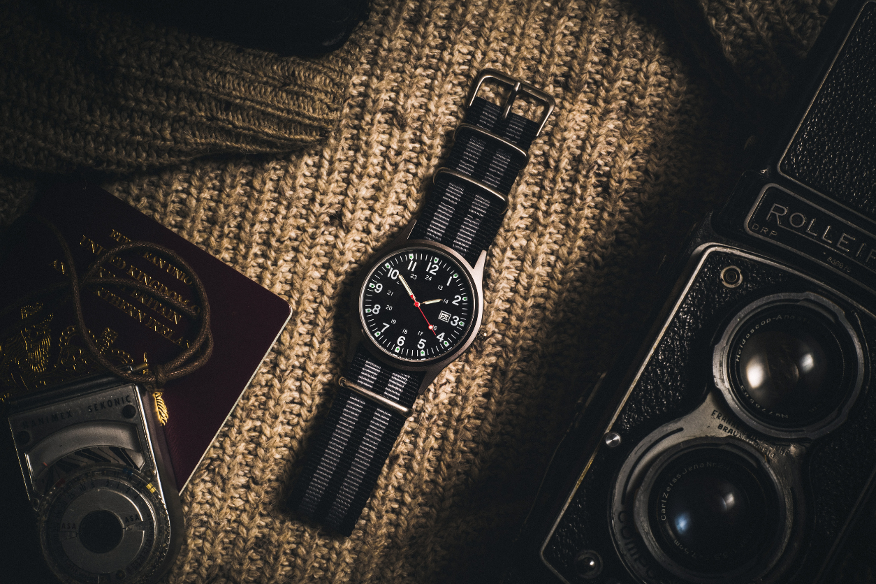 Foto: Eine Armbanduhr, Reisepass, Kamera