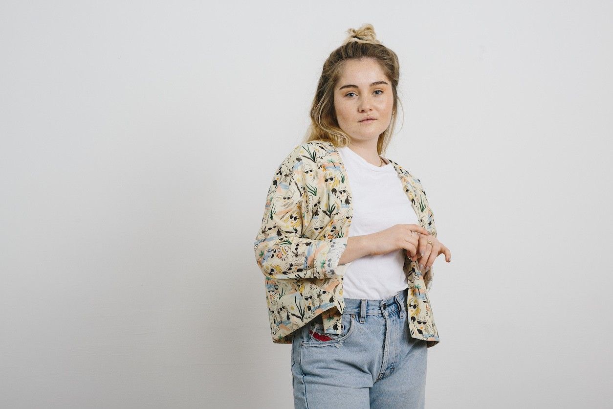 Foto: Eine Frau in Jeans, weißen Tshirt und buntem Hemd