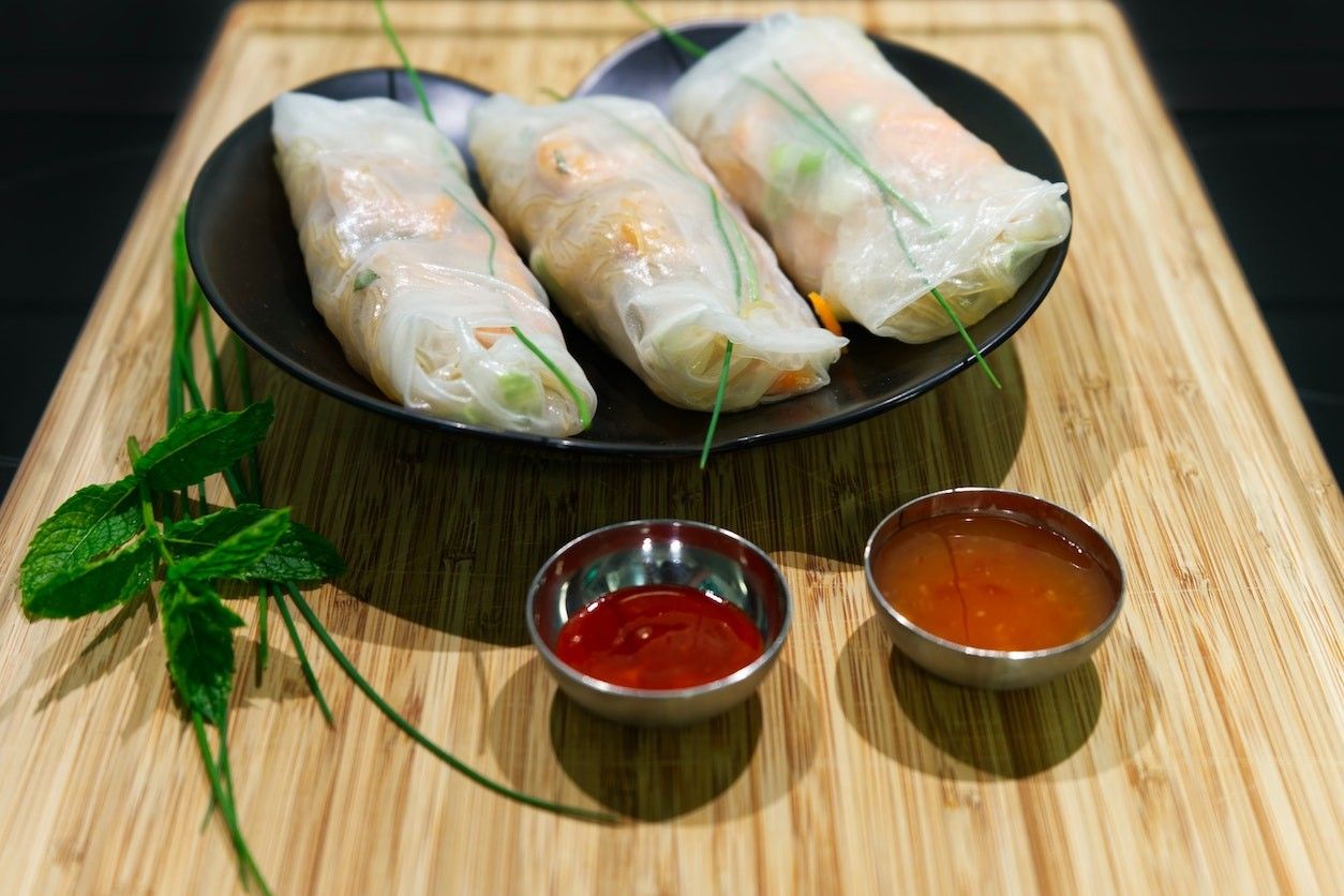 Foto: Ein Teller mit Sommerrollen und zwei Saucenschalen