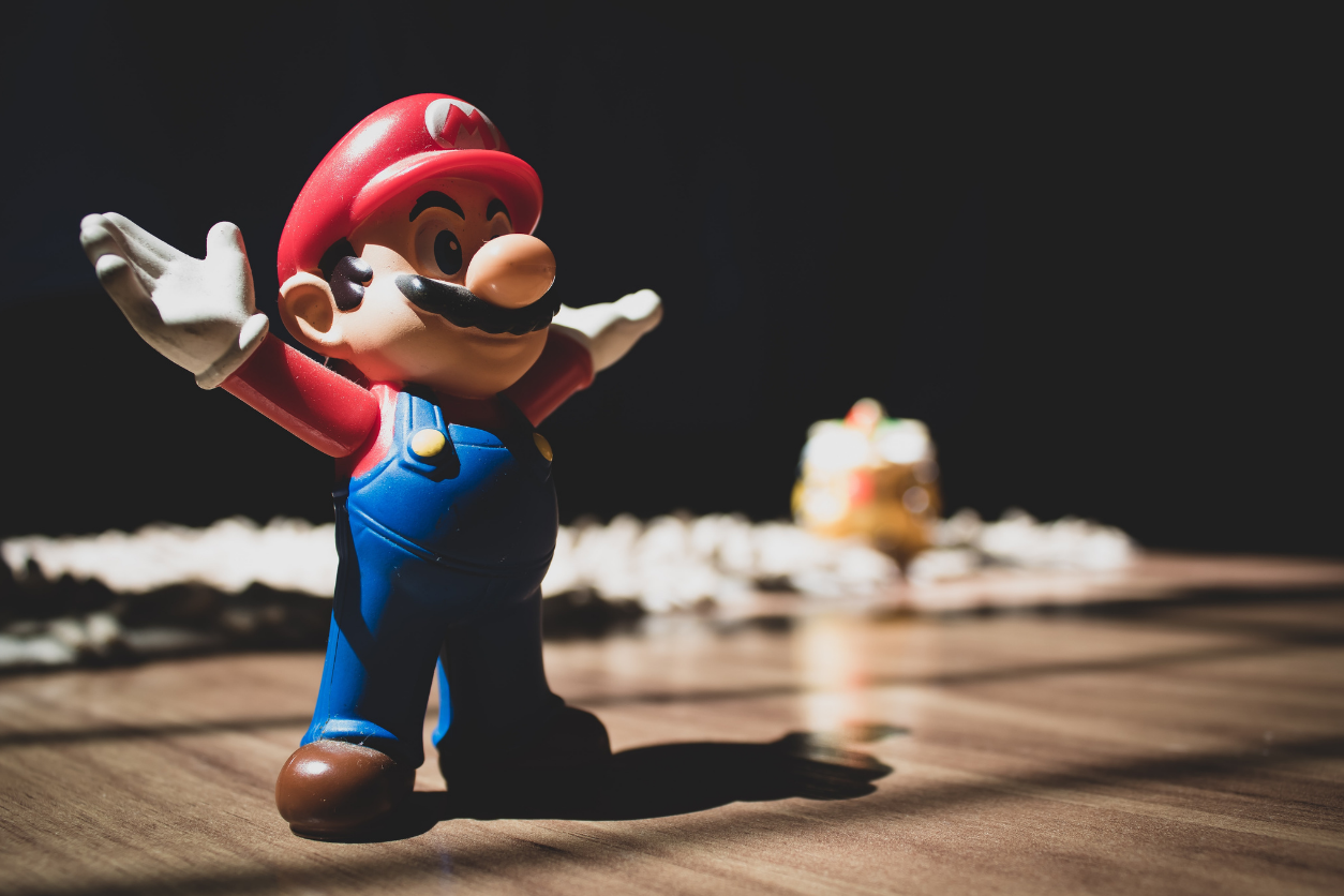 Foto: Super Mario steht auf einem Tisch und hebt die Arme