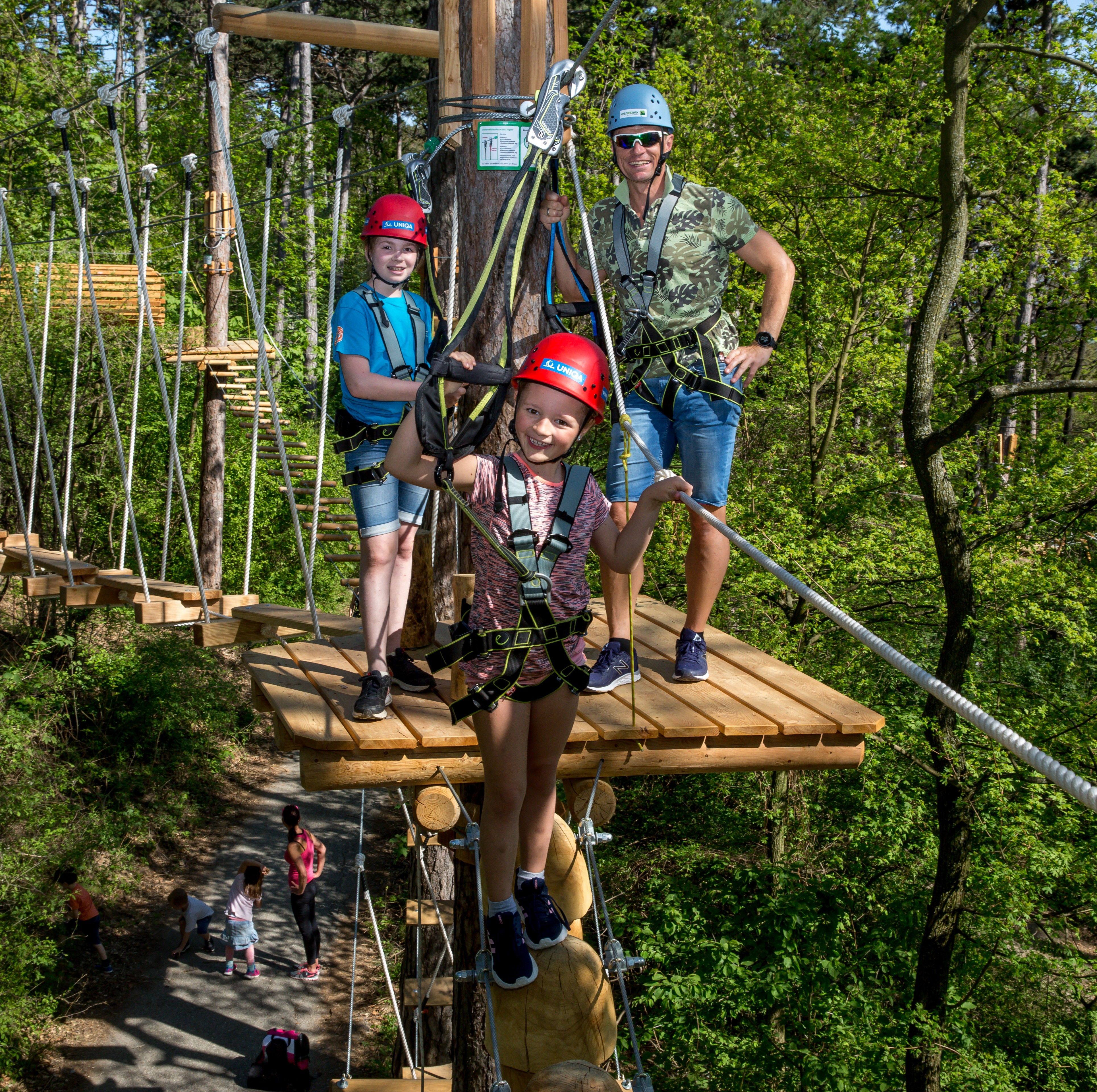 Foto: Zwei Kinder und ein Mann sind im Hochseilgarten